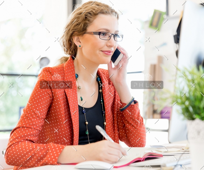 young-woman-holding-mobile-phone-in-office-PE9ARDR